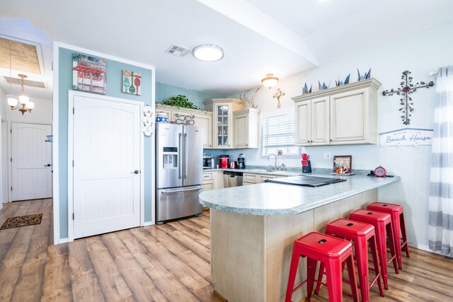 kitchen featuring light countertops, a peninsula, light wood-style floors, a breakfast bar, and stainless steel appliances