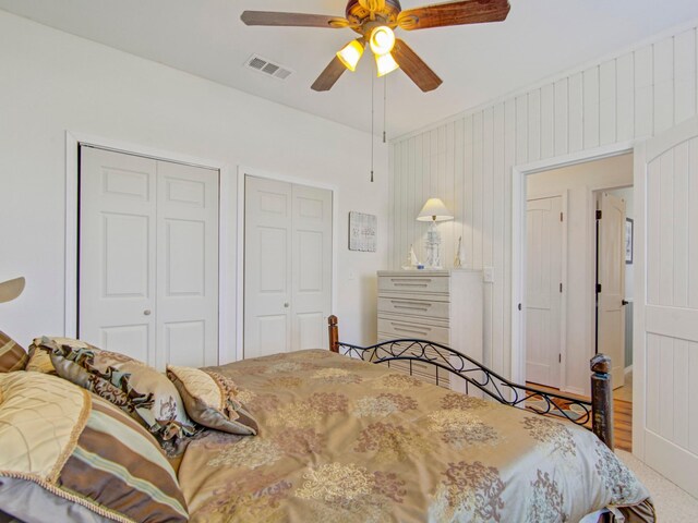 bedroom featuring multiple closets, ceiling fan, and visible vents