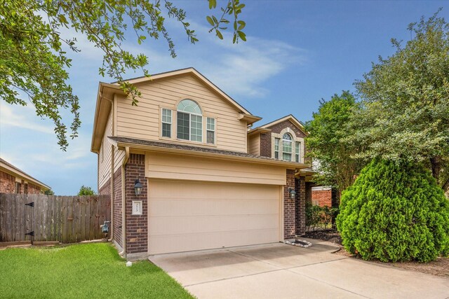 traditional-style home featuring brick siding, a garage, fence, and driveway