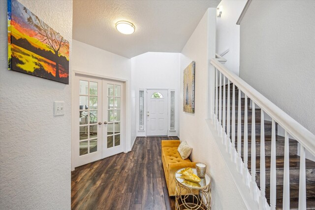 interior space featuring a textured wall, stairs, wood finished floors, a textured ceiling, and french doors