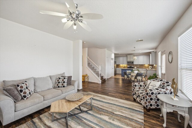 living room featuring a ceiling fan, stairs, and wood finished floors