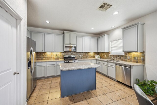 kitchen featuring a center island, backsplash, stainless steel appliances, and visible vents