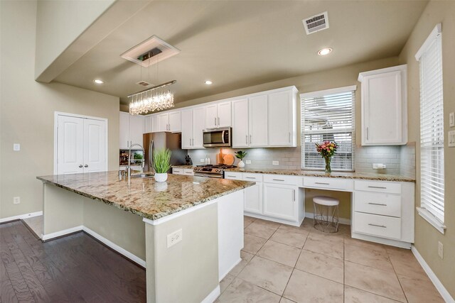 kitchen with visible vents, appliances with stainless steel finishes, white cabinets, and tasteful backsplash