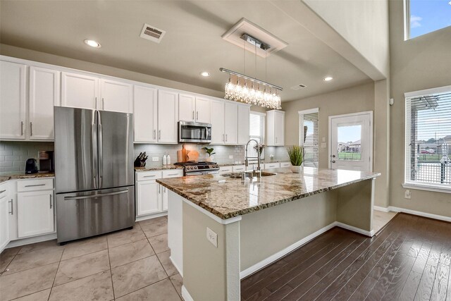 kitchen featuring appliances with stainless steel finishes, plenty of natural light, a sink, and visible vents