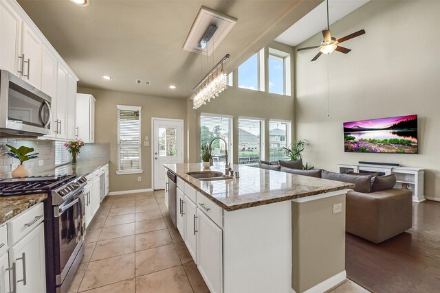 kitchen featuring ceiling fan, appliances with stainless steel finishes, a sink, open floor plan, and recessed lighting