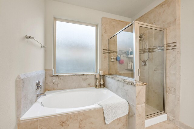 bathroom featuring a garden tub, a stall shower, and a healthy amount of sunlight