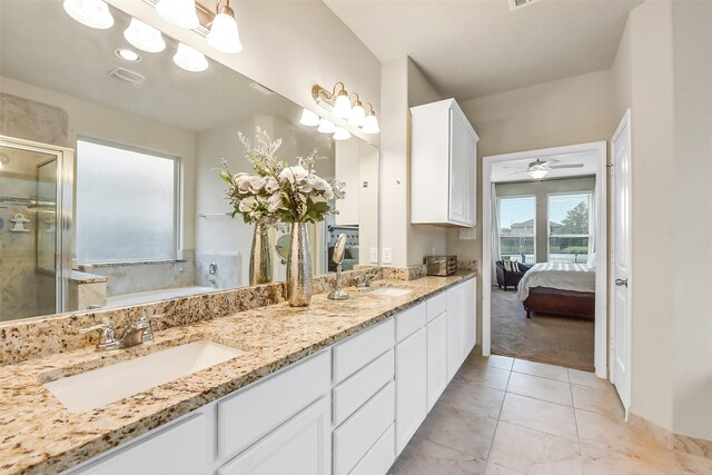 bathroom with double vanity, a sink, a garden tub, and a stall shower