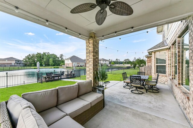 view of patio with ceiling fan, outdoor dining area, a fenced backyard, an outdoor living space, and a water view