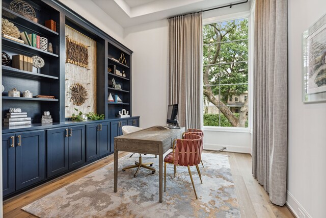 home office featuring baseboards, plenty of natural light, and light wood finished floors