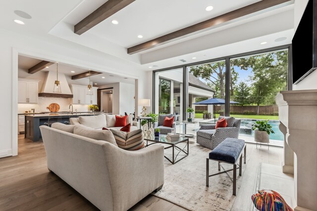 living area with recessed lighting, beam ceiling, and light wood finished floors