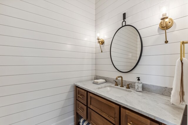 bathroom featuring vanity and wooden walls