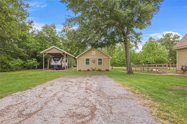 bungalow featuring fence, a front yard, and a carport