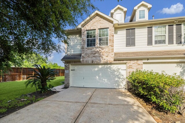 view of front facade featuring a garage, a front lawn, fence, brick siding, and driveway