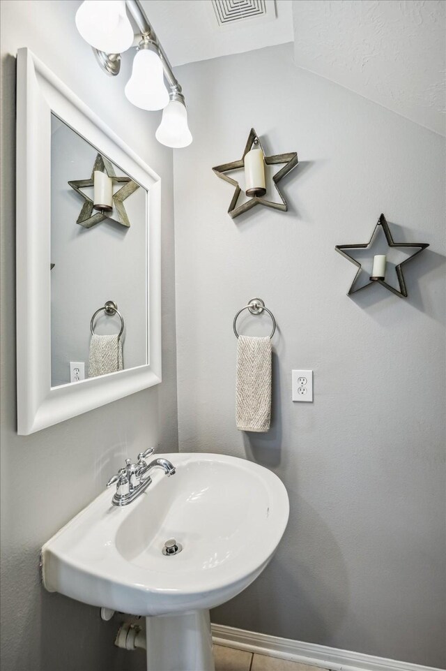 bathroom featuring visible vents, a sink, and lofted ceiling