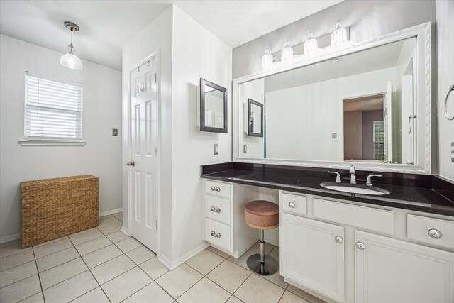 bathroom featuring tile patterned flooring, baseboards, and vanity