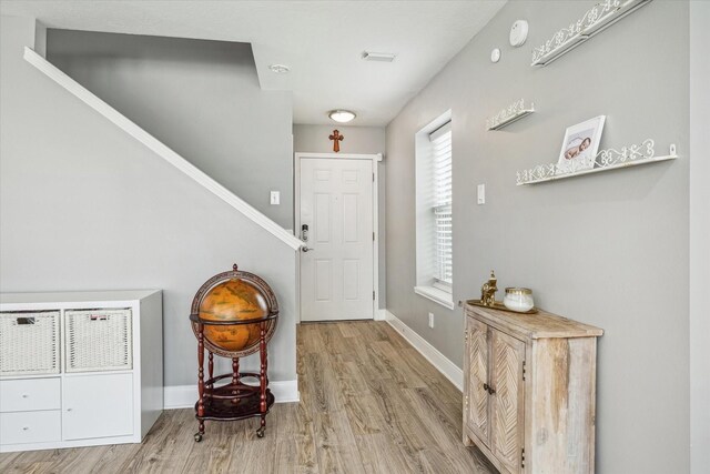 entryway with baseboards and wood finished floors