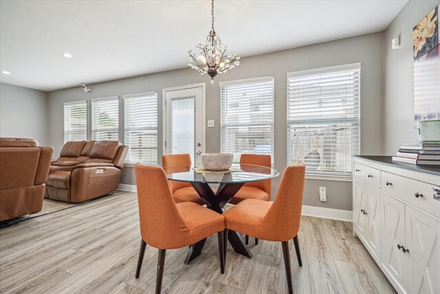 dining space with baseboards, recessed lighting, light wood-style flooring, and a notable chandelier