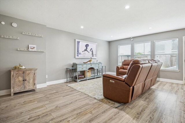 living area featuring baseboards, recessed lighting, and wood finished floors