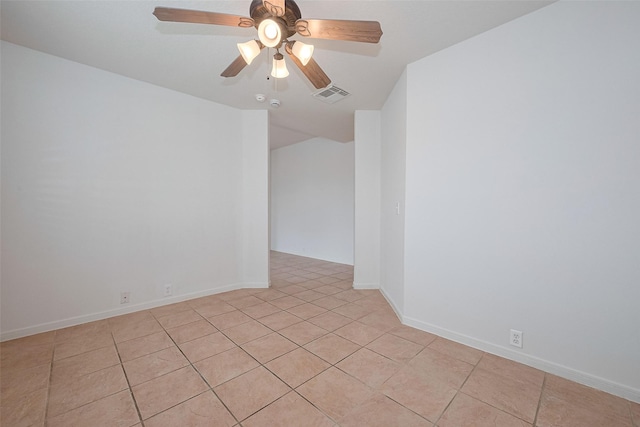 spare room with light tile patterned flooring, a ceiling fan, visible vents, and baseboards