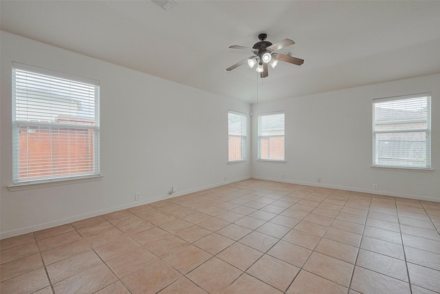 empty room with baseboards, a ceiling fan, and light tile patterned flooring