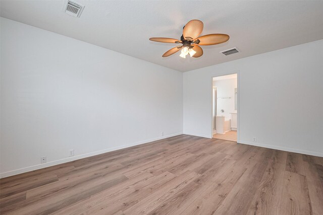spare room with visible vents, a ceiling fan, light wood finished floors, and baseboards
