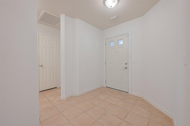 entryway featuring baseboards, visible vents, and light tile patterned floors