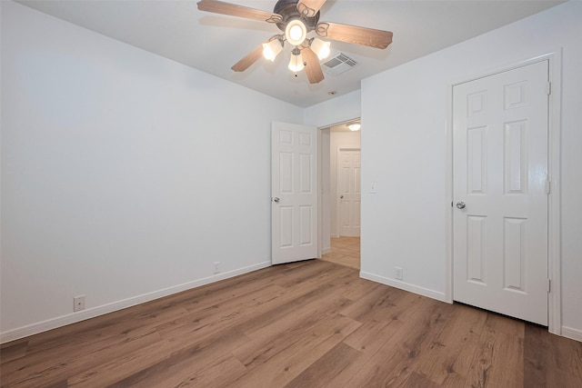 unfurnished bedroom featuring visible vents, baseboards, ceiling fan, and wood finished floors
