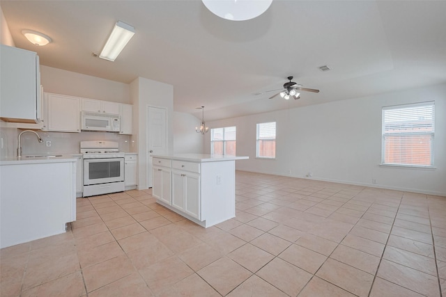 kitchen with white appliances, light countertops, a sink, ceiling fan with notable chandelier, and light tile patterned floors