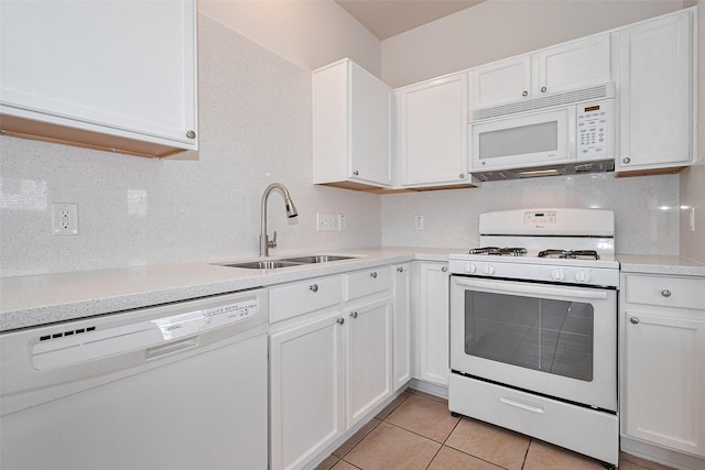 kitchen with white cabinets, a sink, white appliances, light countertops, and light tile patterned floors