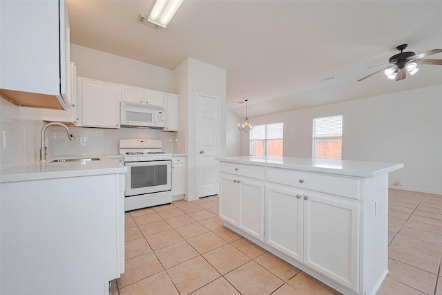 kitchen with white appliances, a sink, light tile patterned floors, and light countertops