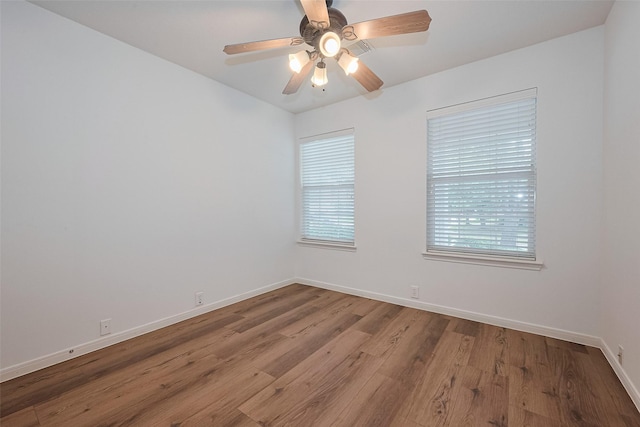 unfurnished room featuring a ceiling fan, baseboards, plenty of natural light, and wood finished floors