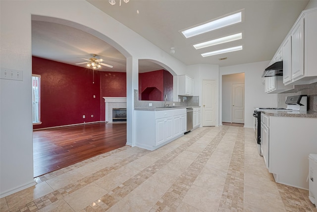 526 Majestic Ridge Dr, Houston, TX 77049 - kitchen with stainless steel dishwasher, electric range, ceiling fan, white cabinetry, and under cabinet range hood