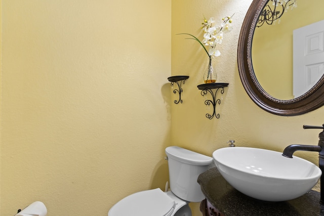 half bathroom featuring toilet and a sink
