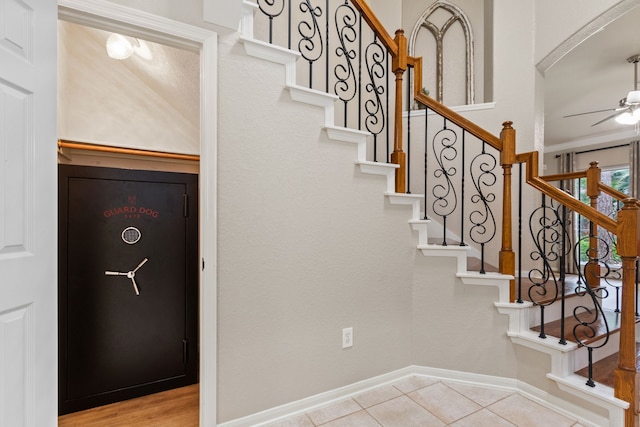 stairs with baseboards, a ceiling fan, and tile patterned floors