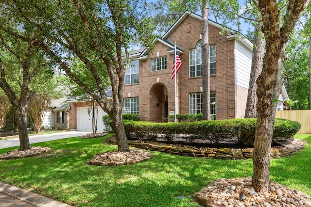 traditional-style house with brick siding, fence, a front yard, and concrete driveway