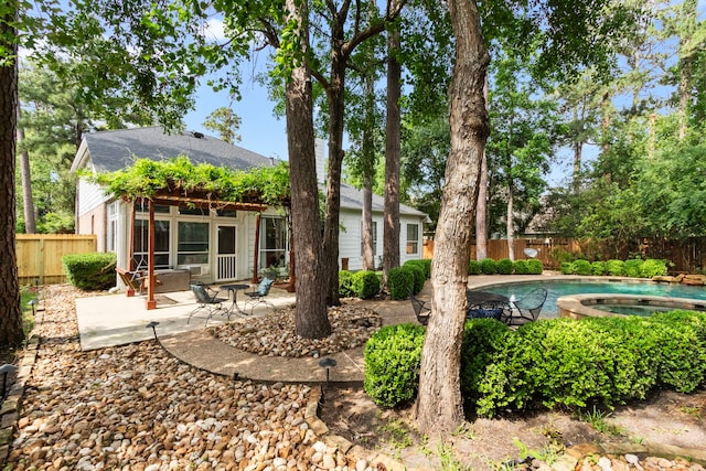 rear view of house featuring a fenced in pool, a fenced backyard, an in ground hot tub, and a patio area