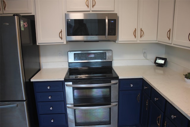 6106 W Airport Blvd Unit 18, Houston, TX 77035 - kitchen with appliances with stainless steel finishes, blue cabinets, white cabinets, and light stone counters