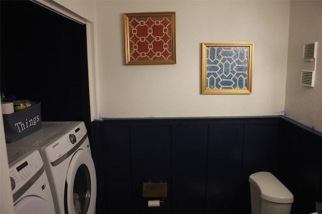 6106 W Airport Blvd Unit 18, Houston, TX 77035 - washroom featuring washing machine and clothes dryer, a decorative wall, and wainscoting