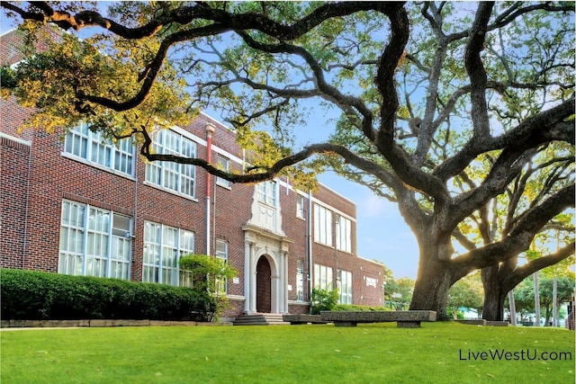 view of front facade with brick siding and a front lawn