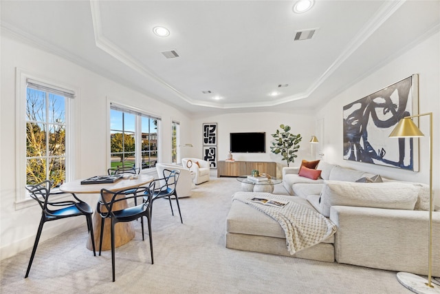 living area with visible vents, crown molding, recessed lighting, light colored carpet, and a tray ceiling