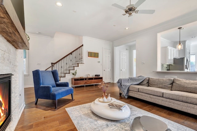 1267 Sopris Dr, Houston, TX 77077 - living area featuring ornamental molding, a fireplace, light wood-style floors, stairway, and ceiling fan