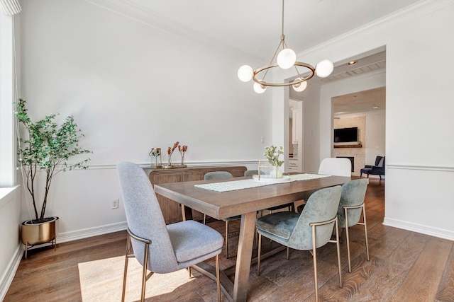 1267 Sopris Dr, Houston, TX 77077 - dining room featuring wood finished floors, crown molding, a chandelier, a fireplace, and baseboards