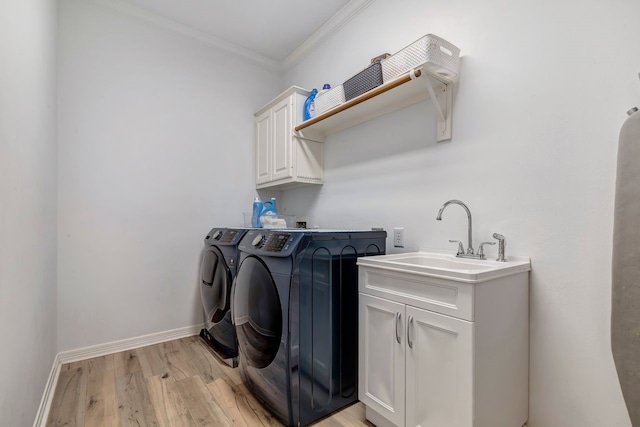 1267 Sopris Dr, Houston, TX 77077 - washroom with washing machine and dryer, cabinet space, crown molding, light wood-style flooring, and baseboards