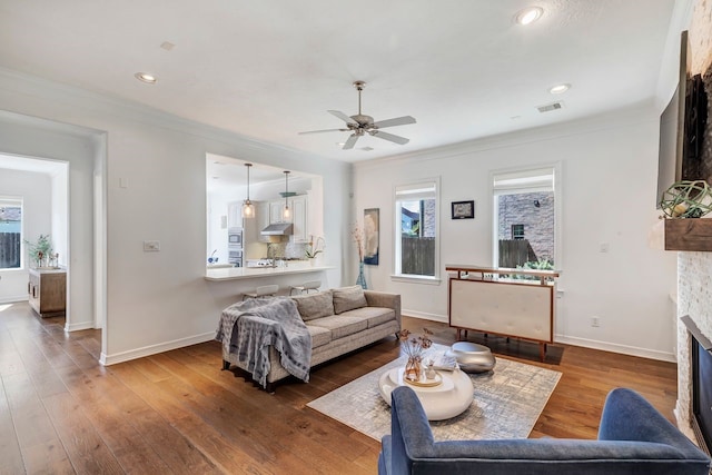 1267 Sopris Dr, Houston, TX 77077 - living room with a glass covered fireplace, a ceiling fan, ornamental molding, baseboards, and hardwood / wood-style flooring