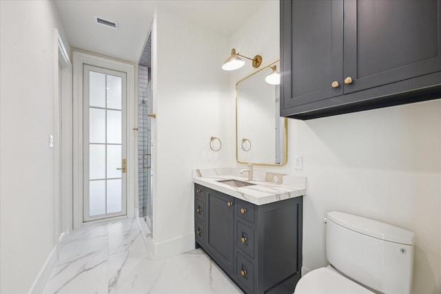 bathroom with baseboards, marble finish floors, toilet, vanity, and a shower stall