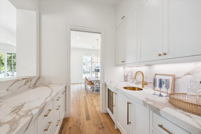 bar area featuring a sink, light wood-style flooring, and recessed lighting