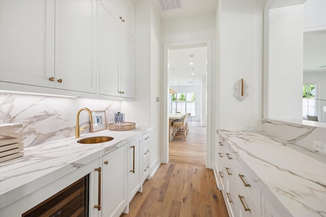 4230 Whitman St, Houston, TX 77027 - bar area featuring a sink, beverage cooler, healthy amount of natural light, and light wood-type flooring