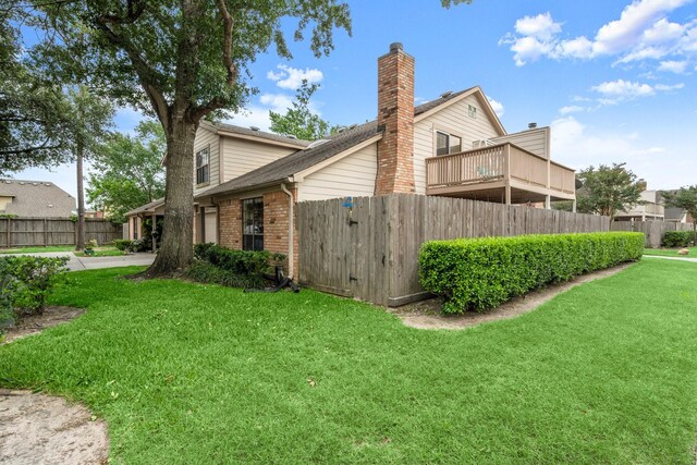 view of home's exterior with a yard, brick siding, and fence
