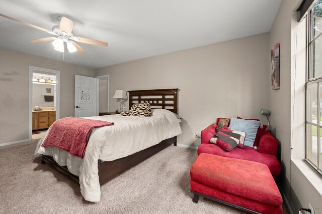 carpeted bedroom featuring baseboards, multiple windows, ceiling fan, and connected bathroom