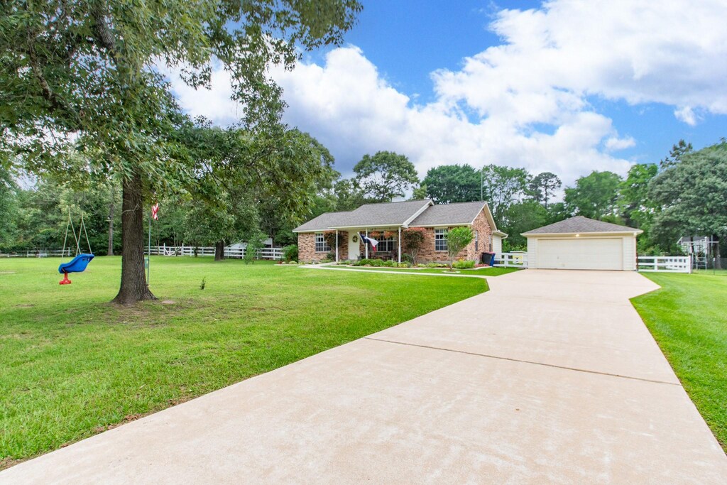 view of front of property with a garage, fence, and a front lawn